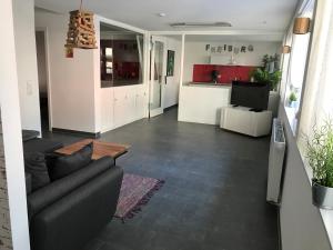 a living room with a couch and a kitchen at Bobbele Freiburg Zentrum in Freiburg im Breisgau