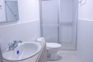 a white bathroom with a toilet and a sink at OMA HOTEL LA GUAJIRA in Camarones +18 photos