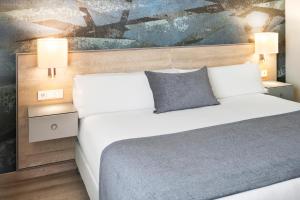 Un dormitorio con una cama y un cuadro en la pared. en Salles Ciutat del Prat Barcelona Airport, en El Prat de Llobregat