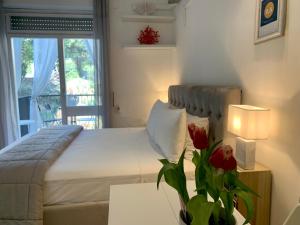 una camera da letto con un letto e un tavolo con un vaso di fiori di Residence Villa Alba a Gardone Riviera