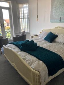 um quarto com 2 camas com almofadas azuis em Lazy Waves Boutique B&B em Newquay