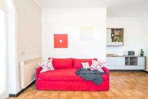 a red couch sitting in a living room at Gardappartamenti Campiello Pool in Sirmione