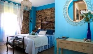 - une chambre bleue avec un lit et un miroir dans l'établissement A Lume Manso - Adults Only, à Barreiros