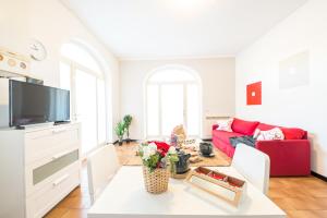 a living room with a red couch and a table at Gardappartamenti Campiello Pool in Sirmione