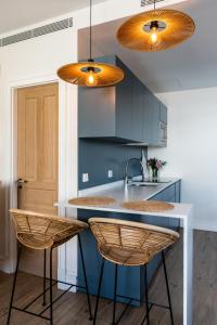 a kitchen with blue cabinets and a sink and two lights at Honest Sevilla Apartments in Seville