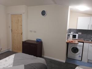 a small kitchen with a bed and a microwave at 2-Beds Studio Located in Parkgate Rotherham in Rotherham