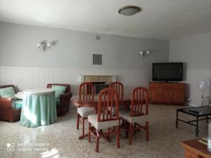 sala de estar con mesa, sillas y TV en Casa rural Victoria, en Valdelamatanza