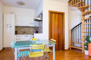 uma cozinha com uma mesa azul e cadeiras amarelas em Garda Almonds em Desenzano del Garda