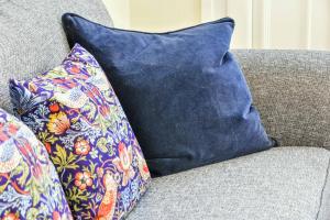 a blue pillow sitting on top of a couch at Bay tree Cottage in York