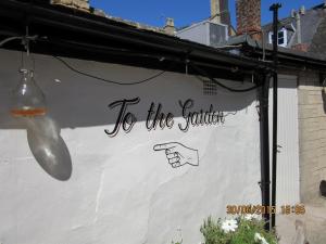 a sign that says to the garden on the side of a building at The Bell Inn in Moreton in Marsh