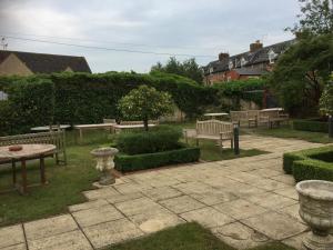 a park with benches and a table and a table and chairs at The Bell Inn in Moreton in Marsh