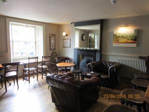 a living room with leather furniture and a fireplace at The Bell Inn in Moreton in Marsh