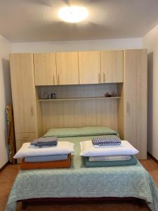 um quarto com 2 camas e armários de madeira em Caorle & Caorle em Caorle