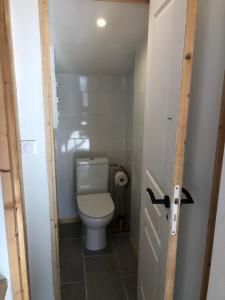 Baño pequeño con aseo y puerta en La Bicoque d'Opale à deux pas de la plage, en Ambleteuse