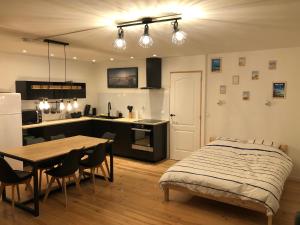 1 dormitorio con cama, mesa y cocina en La Bicoque d'Opale à deux pas de la plage, en Ambleteuse