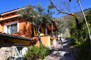 ein Haus auf einem Hügel mit Bäumen und einem Gehweg in der Unterkunft Costa del Gallo in Pacentro