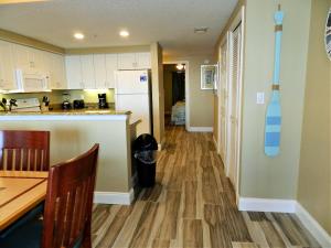 a kitchen with a table and a refrigerator at 3 BR Direct Oceanfront Condo Wyndham Ocean Walk Resort - Daytona Funland 1023 in Daytona Beach