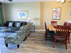 a living room with a couch and a table and chairs at 3 BR Direct Oceanfront Condo Wyndham Ocean Walk Resort - Daytona Funland 1023 in Daytona Beach