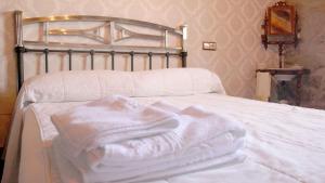 a pile of white towels sitting on top of a bed at Casa Rural La Centenaria de Alaraz in Alaraz