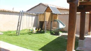 a playground in a yard with a swing at Casa Rural La Centenaria de Alaraz 