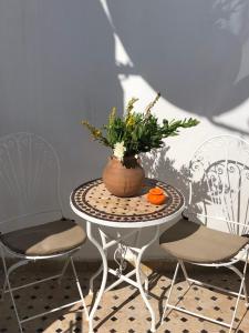 a table with a vase of flowers and two chairs at Kasba blanca in Tangier
