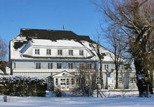 Una gran casa blanca con nieve encima. en Haus Antje en Ahrenshoop