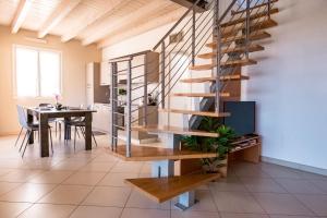 escalera de caracol en una sala de estar con mesa de comedor en Residenza Oleandro, en Desenzano del Garda