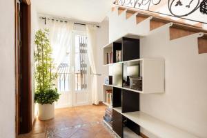 een woonkamer met een boekenplank en een trap bij AR Alojamiento Rural in Júzcar