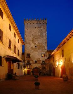 een oud gebouw met een toren op een binnenplaats bij Tenuta Il Corno Agriturismo in San Casciano in Val di Pesa