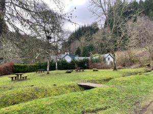 un parque con mesas de picnic en el césped en Foresters Lodge bed and breakfast, near loch ness, en Inverfarigaig