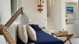 a living room with a blue bed and a lamp at Antheia Suite of Mykonos in Ano Mera