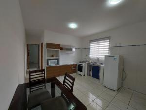 uma cozinha com uma mesa e cadeiras e um frigorífico em Casa de Hóspedes em Parque Pinheiros - Sem Garagem em Taboão da Serra