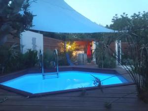 una piscina en un patio trasero por la noche en Secret Garden - Chez Gilles et Tra - Maison d hôte -T2 super mignon, neuf et indépendant , dans cadre agréable et zen, en Valergues
