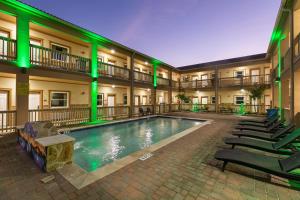 una piscina en el patio de un hotel con luces verdes en El Delfín Lodge en South Padre Island