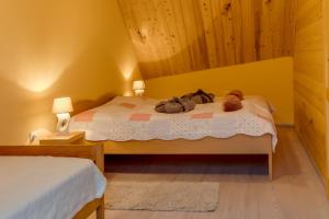 a bedroom with a bed with two stuffed animals on it at Apartman "Ela" in Fužine