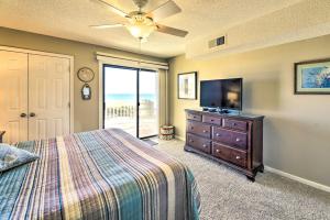a bedroom with a bed and a flat screen tv at Coastal Condo with Indoor and Outdoor Pool Access in Emerald Isle