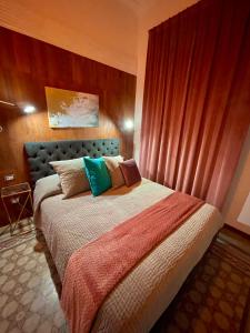 - une chambre avec un grand lit et des oreillers colorés dans l'établissement PALAZZO FIACCADORI - Historical Palace, à Reggio de Calabre