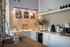 a kitchen with white cabinets and a wooden counter top at LT - Room's Bed & Living in Monza