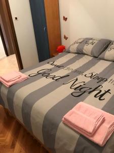 a bed with a comforter on it with two towels at Apartman Ivanka in Barbat na Rabu