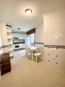 a large kitchen with a table and chairs in it at Piso Os Pazos in Cambados