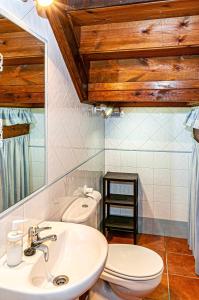 a bathroom with a sink and a toilet and a mirror at Casa Sabina, Zona de playa y montaña in Llanes