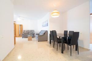 ein Esszimmer mit einem Tisch und schwarzen Stühlen in der Unterkunft Global Properties, Increible apartamento en la playa, Canet d'en Berenguer in Canet d'en Berenguer