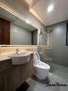 a bathroom with a sink and a toilet and a mirror at Premium Swanhouse no.SiX with 3bedrooms Condo in Sibu