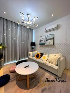 een woonkamer met een bank en een tafel bij Premium Swanhouse no.SiX with 3bedrooms Condo in Sibu