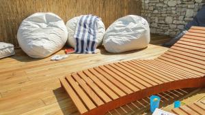 three pillows and a bench on a wooden floor at Eco Sunshine Apartments Lumbarda in Lumbarda