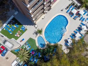 an overhead view of a large swimming pool with lawn chairs at Aparthotel BCL Levante Beach in Benidorm
