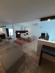 a large bedroom with two beds and a living room at Carpinchos De Otamendi in Campana