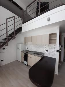 a kitchen with a stove top oven next to a loft at Carpinchos De Otamendi in Campana