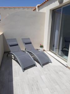 - un ensemble de chaises assises sur une terrasse dans l'établissement Appartamenti in paese a poca distanza dal mare, à Lampedusa