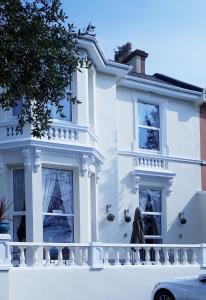 a woman walking in front of a white house at The Netley in Torquay